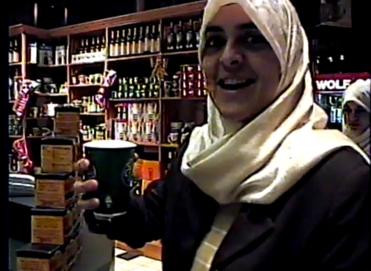 Muaz’s mother holding a cup in front of the counter